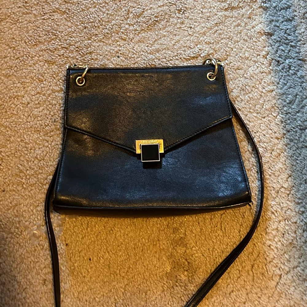 Kate Landry black leather purse, medium sized, uses a magnetic snap.
